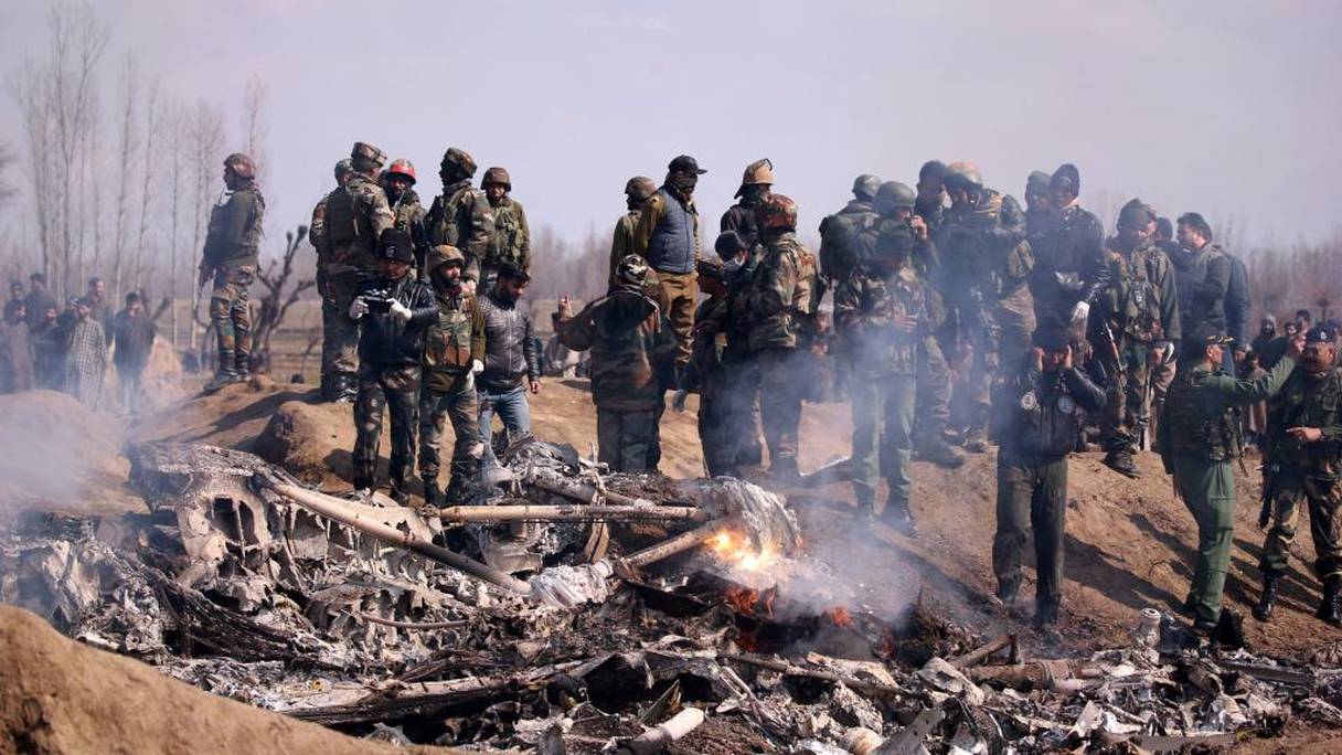 Des soldats pakistanais se tiennent devant les débris d'un hélicoptère de l'Indian Air Force détruit dans le district de Budgam, le 27 février 2019.
