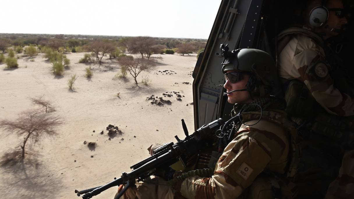 Un soldat français survole le désert à bord de l'hélicoptère de l'armée française NH 90 "Caïman", le 1er juin 2015, près de Gao, lors de l'opération Barkhane, une opération antiterroriste au Sahel.

