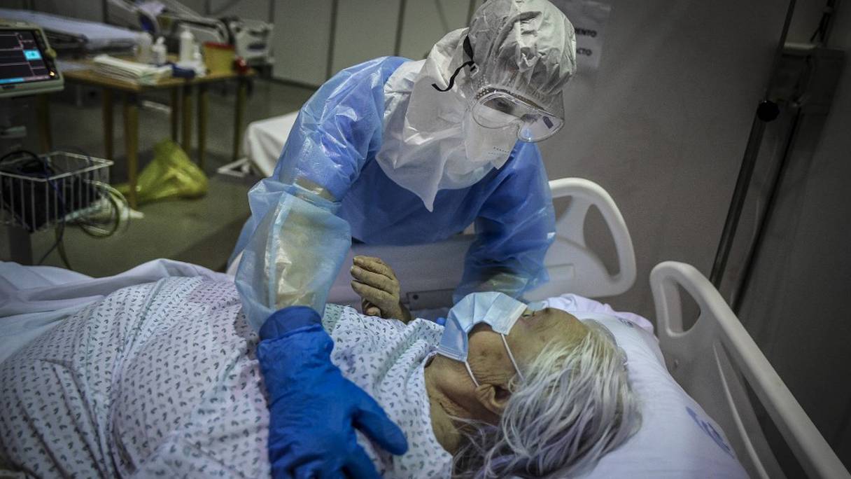 Un professionnel de la santé s'occupe d'un patient au pavillon sportif de Portimao Arena, converti en hôpital de campagne pour patients Covid-19 à Portimao, dans la région de l'Algarve, au Portugal, le 9 février 2021.
