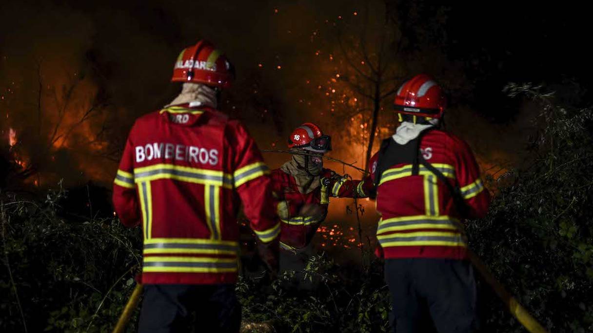 Les pompiers luttent contre un feu de forêt autour du village d'Eiriz à Baiao, au nord du Portugal, le 15 juillet 2022.
