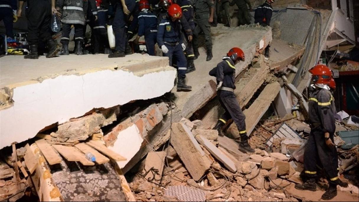 Les agents de la protection civile dans les décombres d'un immeuble.
