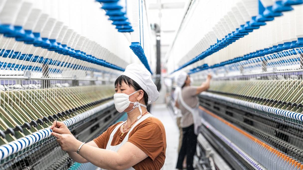 Une employée travaille dans une usine textile à Nantong, dans la province chinoise du Jiangsu, dans l'est de la Chine, le 15 juillet 2021.
