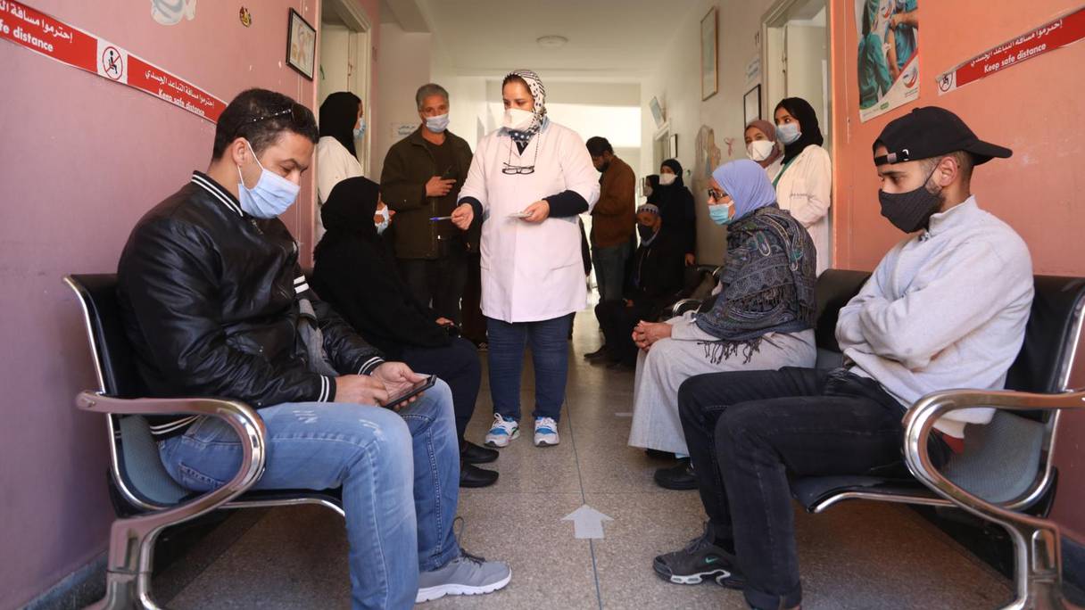 Des personnes attendent leur tour pour recevoir une injection d'un vaccin anti-Covid-19, à Marrakech, le 31 décembre 2021. 

