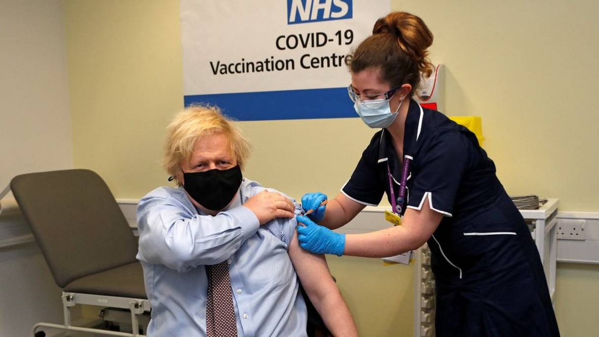 Le Premier ministre britannique Boris Johnson reçoit sa première dose du vaccin anti-Covid-19 développé par AstraZeneca en partenariat avec Oxford, au centre de vaccination de l'hôpital St Thomas de Londres, le 19 mars 2021. 
