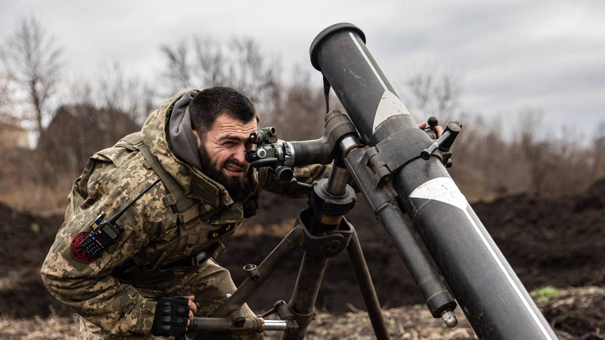 Un soldat en treillis ukrainien se prépare à lancer un tir de mortier vers les positions russes de Bakhmout, dans l'est de l'Ukraine, le 30 décembre 2022.
