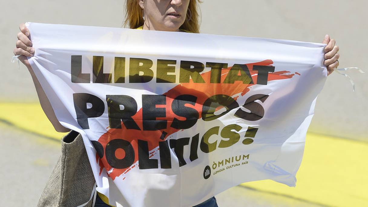 Une femme brandit une banderole "Liberté pour les prisonniers politiques", à proximité de la prison de Lledoners, le 4 juillet 2018.
