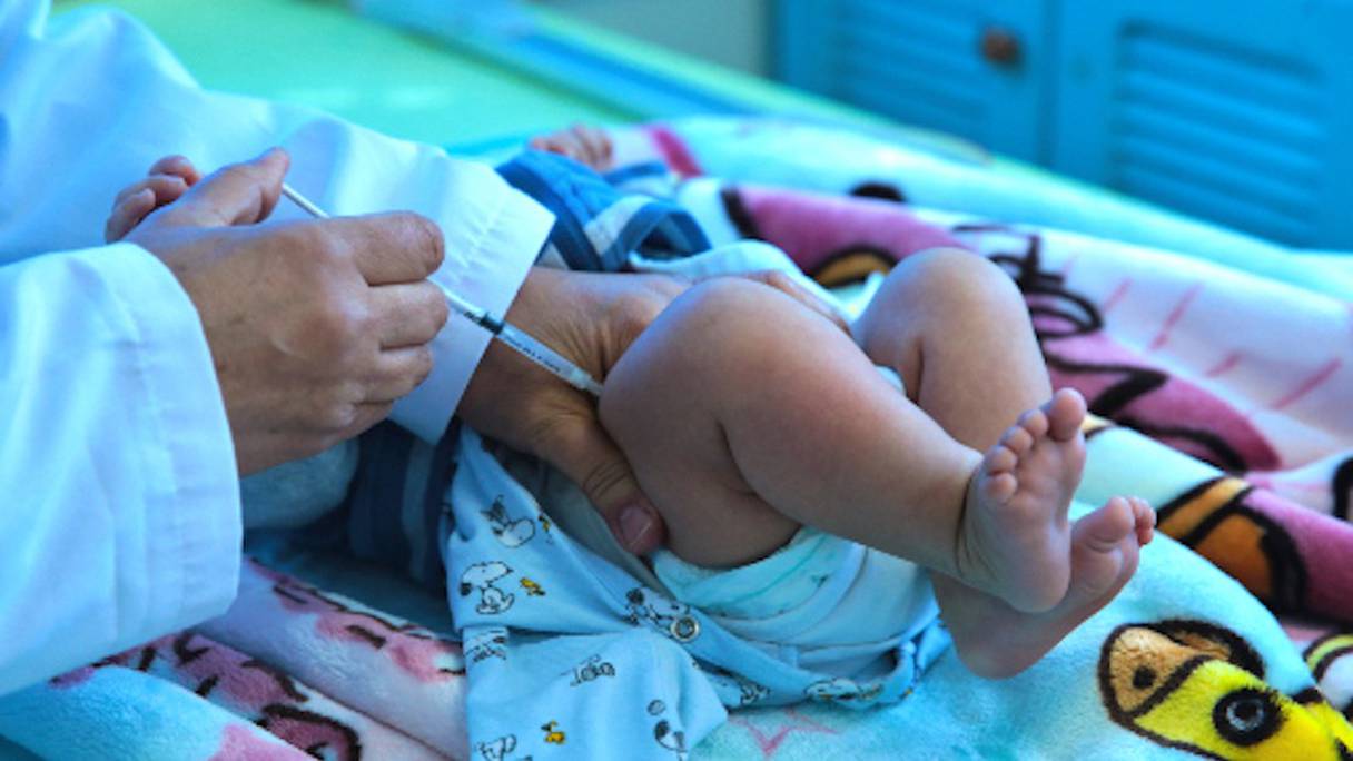 Un nourrisson reçoit un vaccin d'un pédiatre dans son cabinet médical, au Maroc.
