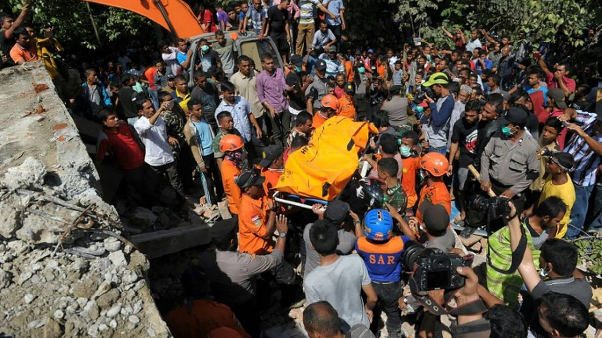 Des équipes de secours retirent le corps d'une victime, le 7 décembre 2016 à Pidie, en Indonésie.
