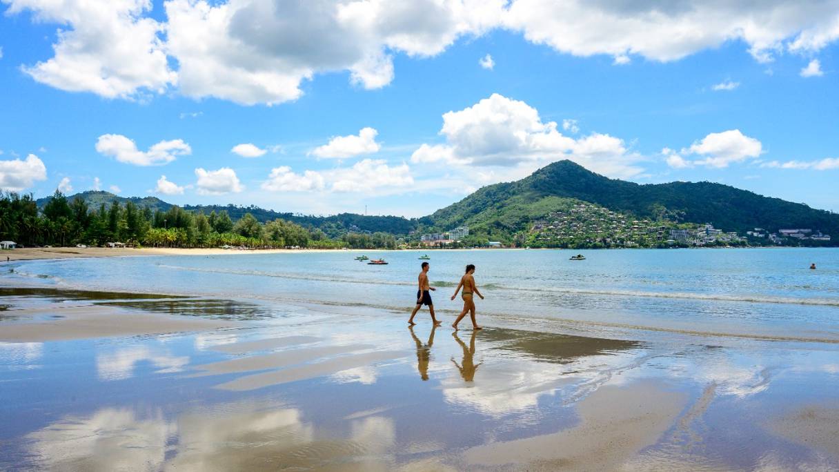 Des touristes marchent sur une plage de l'île thaïlandaise de Phuket, le 1er novembre 2021.
