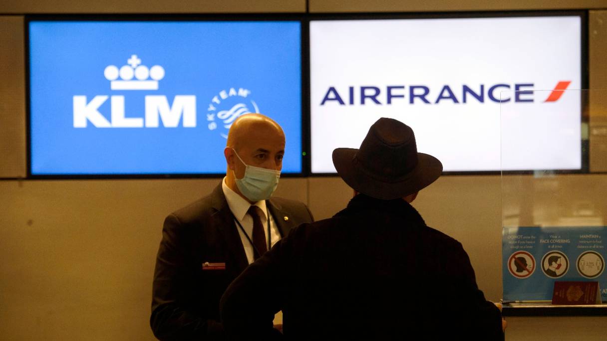 Un employé reçoit au comptoir d'Air France KLM des passagers pour leur enregistrement, à l'aéroport international de Los Angeles (LAX), le 25 janvier 2021, en Californie.
