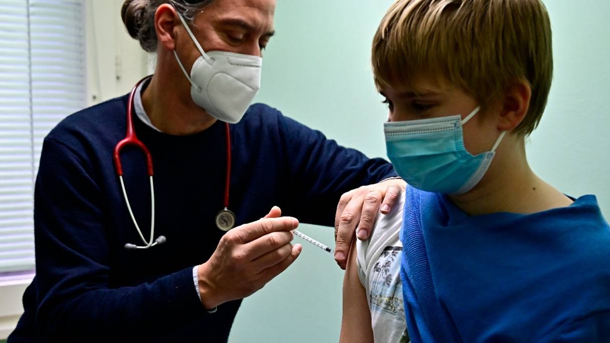 Un médecin pédiatre vaccine un garçon de 11 ans dans son cabinet à Berlin le 14 décembre 2021, au début de la campagne de vaccination anti-Covid-19 pour les enfants de moins de 12 ans en Allemagne.
