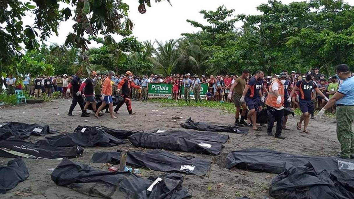 Des sauveteurs transportent un sac mortuaire contenant le cadavre d'une victime d'un glissement de terrain qui a frappé le village de Pilar (province de Leyte), le 13 avril 2022, quelques jours après l'inondation provoquée par la tempête tropicale Megi.
