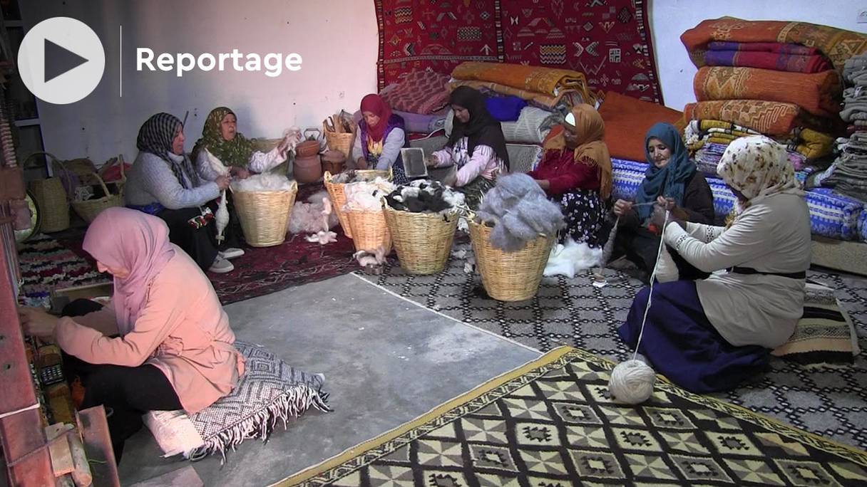 Des femmes de la coopérative Iznaguen féminine de tapis authentiques, en train de tisser des tapis (capture image vidéo). 
