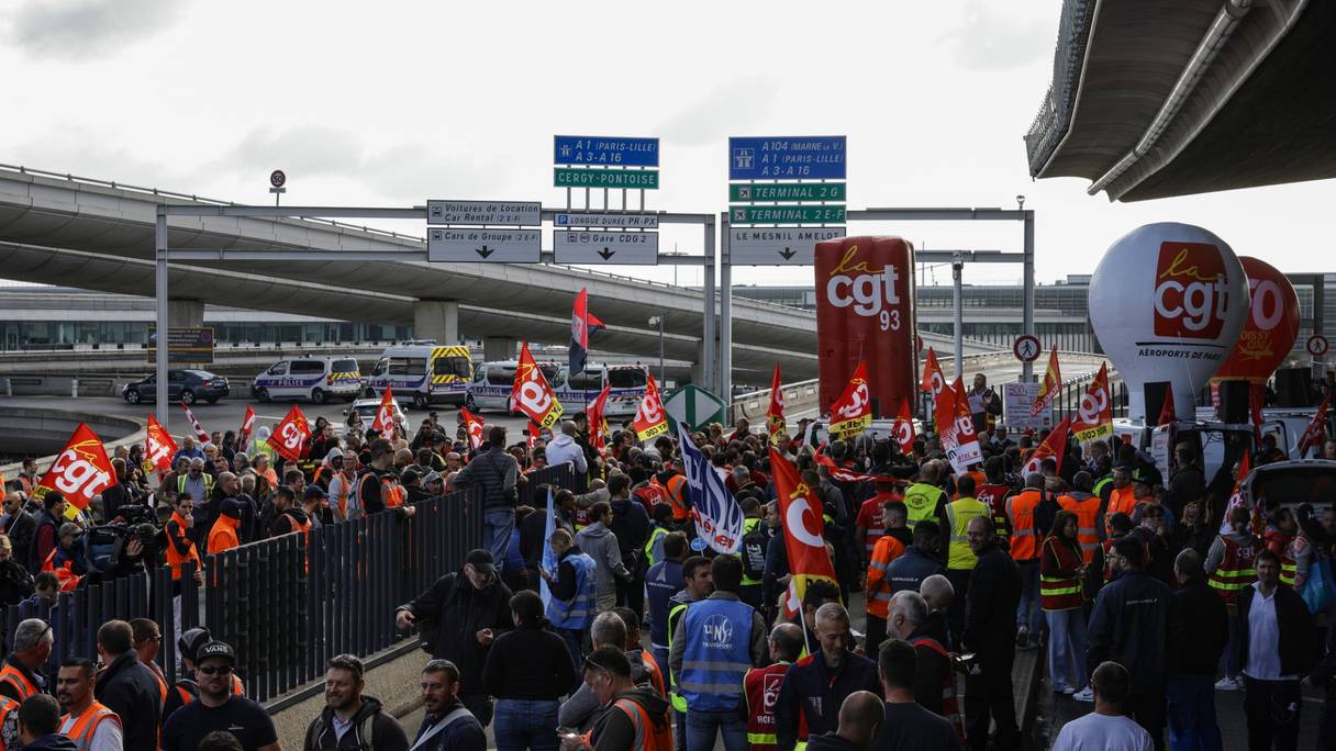 Les employés de l'aéroport Paris Charles de Gaulle se rassemblent devant un terminal alors qu'ils organisent une grève pour exiger des salaires plus élevés à l'aéroport Roissy Charles De Gaulle, au nord de Paris, le 9 juin 2022.
