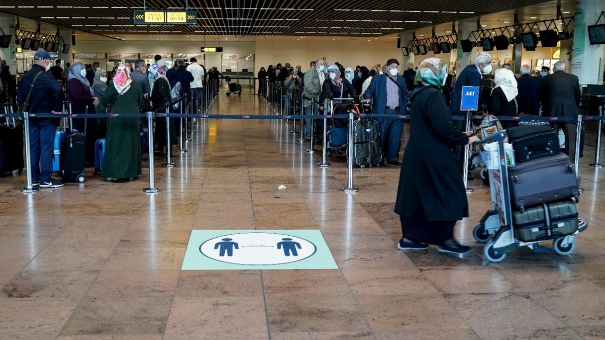 Des passagers font la queue aux comptoirs d'enregistrement de l'aéroport de Bruxelles, à Zaventem, le 15 juin 2020, après une fermeture de plusieurs mois pour endiguer la propagation du coronavirus.
