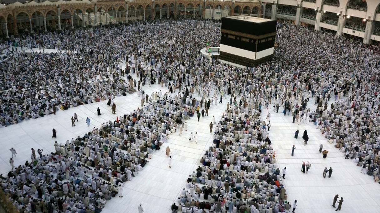 Des pélerins musulmans à proximité de la Kaaba, construction cubique enveloppée d'une lourde étoffe de soie noire brodée au fil d’or de versets coraniques, à La Mecque, le 28 août 2017.
