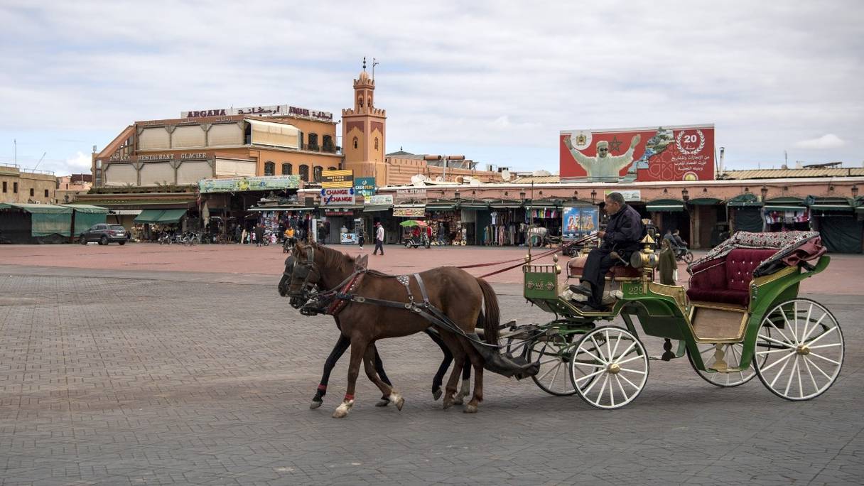 Le conducteur d'une calèche attend des clients sur la place Jemâa el-Fna presque déserte à Marrakech, le 17 mars 2020.
