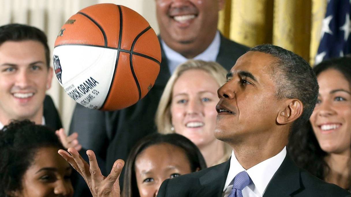 L'ex-président américain Barack Obama maniant une balle de basket.

