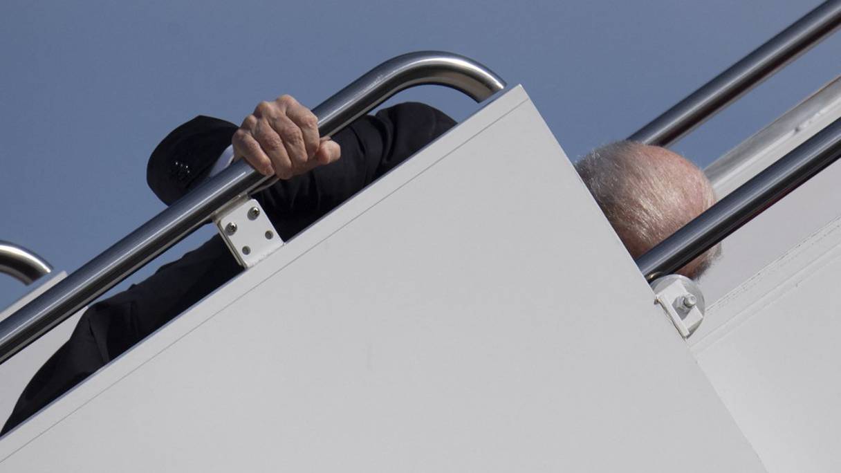 Le président américain Joe Biden s'agrippe à la rampe alors qu'il embarque à bord d'Air Force One, à Joint Base Andrews, dans le Maryland, le 19 mars 2021. Il se rend à Atlanta, en Géorgie, suite aux fusillades dans des salons de massage. 
