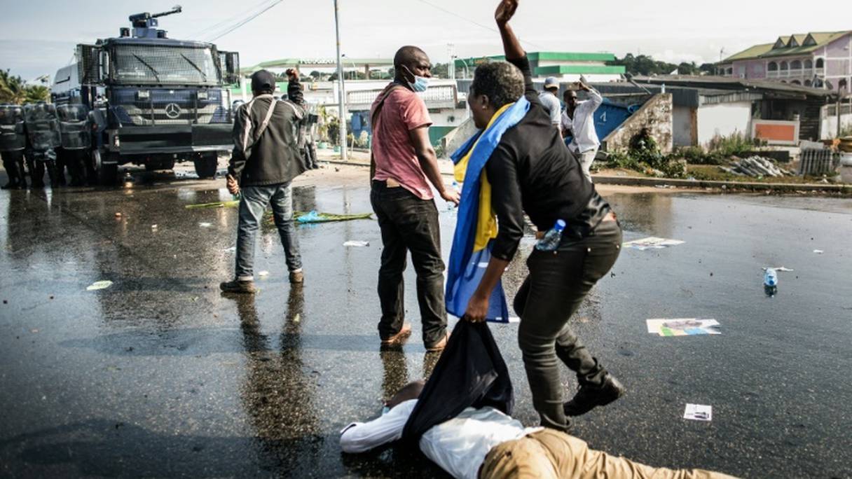 Un partisan de l'opposant gabonais Jean Ping évacue un blessé lors d'une manifestation anti Bongo, le 31 août 2016 à Libreville.
