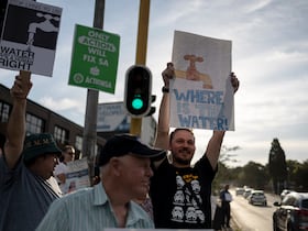 Des habitants brandissent des pancartes lors d'une manifestation contre l'absence d'accès à l'eau dans la région de Blairgowrie, à Johannesburg, le 12 mars 2024.