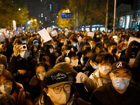 Des manifestants défilent dans une rue, un rassemblement de soutien aux victimes d'un incendie meurtrier à Urumqi (nord-ouest) et de protestation contre les dures restrictions de lutte contre le Covid-19 imposées par la Chine, à Pékin, le 28 novembre 2022.