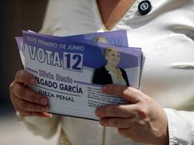 Silvia Rocio Delgado Garcia, candidate au poste de juge pénal de l'État de Chihuahua, tient des dépliants de campagne au pont international Paso del Norte à Ciudad Juarez, État de Chihuahua, Mexique, le 17 mai 2025