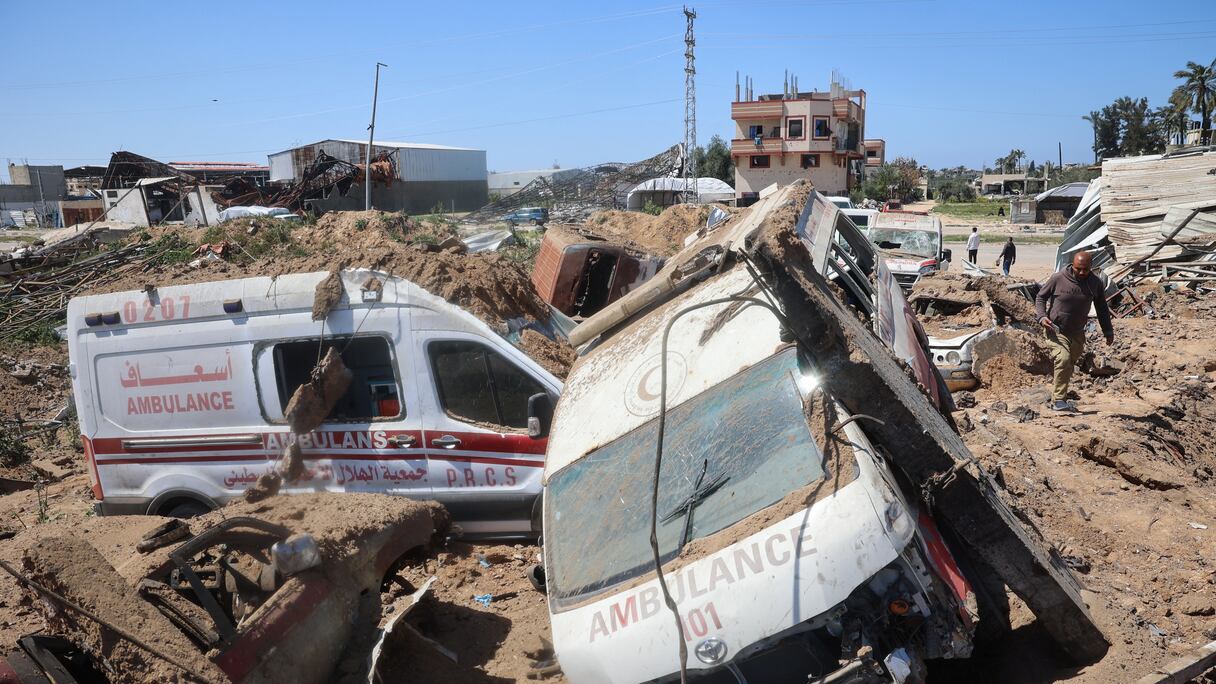 Des Palestiniens inspectent les dégâts sur un chantier de réparation d'ambulances touché par des frappes israéliennes dans le camp de réfugiés d'al-Maghazi, dans le centre de la bande de Gaza, le 24 mars 2025