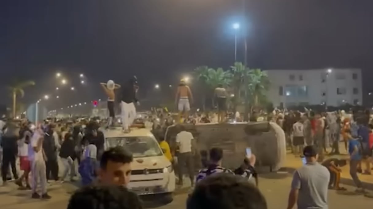 Des émeutiers attaquant deux véhicules de la Sûreté nationale, mercredi 1er octobre à Salé.