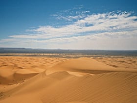 Merzouga. A 35 km de Moulay Ali Cherif, ces dunes, les plus hautes du Maroc, permettent randonnées, bivouacs dans le désert, arénothérapie (ou bains de sable). L'équilibre du site est menacé par la surfréquentation et le développement des sports mécaniques.