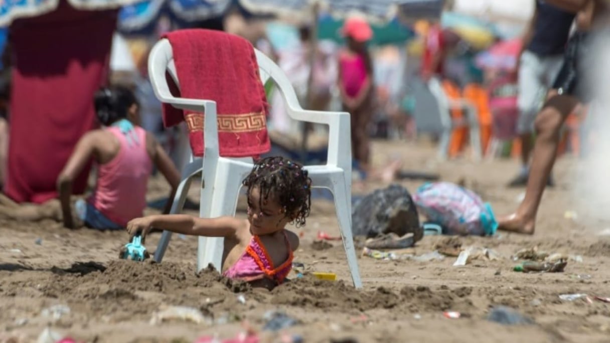 Une petite fille s'amusant sur une plage jonchée de saletés.