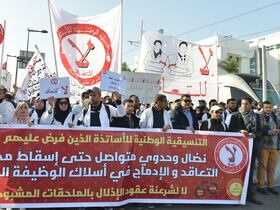 Des enseignants contractuels en pleine manifestation, brandissent banderoles et pancartes.