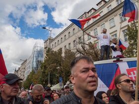 Plusieurs milliers de manifestants, dont des groupes d'extrême-droite et d'extrême-gauche, agitent des drapeaux nationaux alors qu'ils participent à un rassemblement contre le gouvernement, le 28 septembre 2022 à Prague, en Tchéquie.