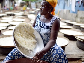 À Abidjan, une femme tamise de la farine de manioc pour la préparation de l'attiéké, un classique de la cuisine ivoirienne