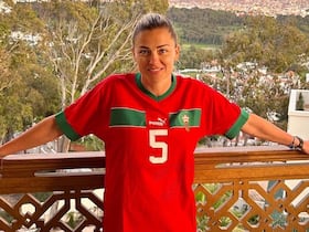 Laure Boulleau, ancienne joueuse du PSG et consultante à Canal+, pose sur un balcon, au Maroc, habillée d'un tee-shirt de l'équipe nationale marocaine.