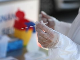 Un membre du corps médical s'apprête à faire un test PCR.