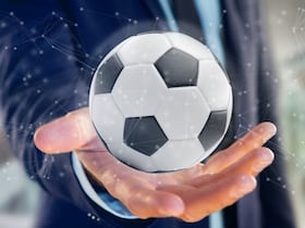 Homme tenant un ballon de foot.