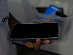 Un élève place son téléphone portable dans une boite en début de journée dans une école de Rio de Janeiro, au Brésil, le 6 février 2025