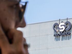 امرأة إسرائيلية تستخدم هاتف iPhone الخاص بها أمام المبنى الذي يضم مجموعة NSO الإسرائيلية في هرتسليا ، بالقرب من تل أبيب.