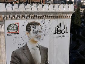 Un portrait criblé de balles du président syrien Bashar al-Assad ornant le bâtiment de la municipalité de Hama