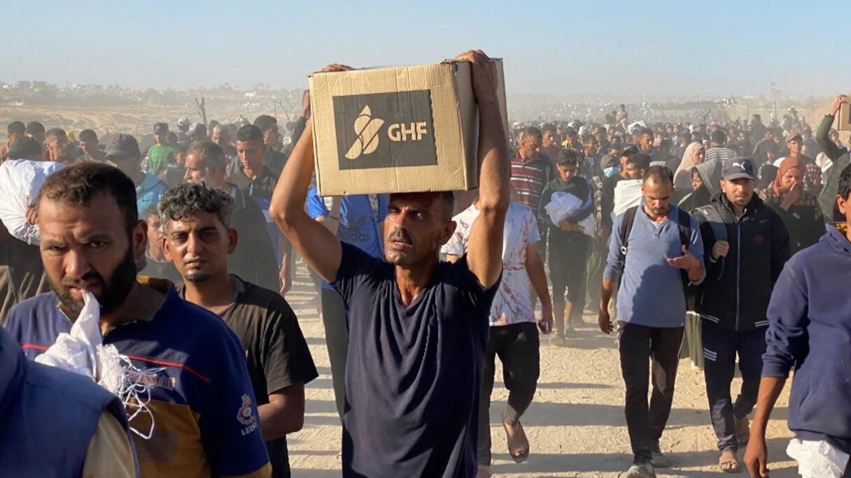 Des Palestiniens déplacés transportent des aides de la Fondation humanitaire pour Gaza (GHF)