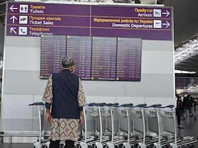 Un homme regarde le tableau des départs, à l'aéroport de Boryspil, à environ 30 kilomètres de Kiev, le 13 février 2022.