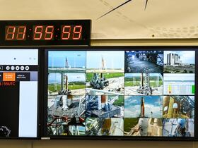 Un écran affiche le décompte et diverses vues en direct de la fusée lunaire sans pilote Artemis I, alors qu'elle se trouve sur la rampe de lancement du Kennedy Space Center, à Cap Canaveral, en Floride, le 28 août 2022, avant son lancement prévu le 29 août.