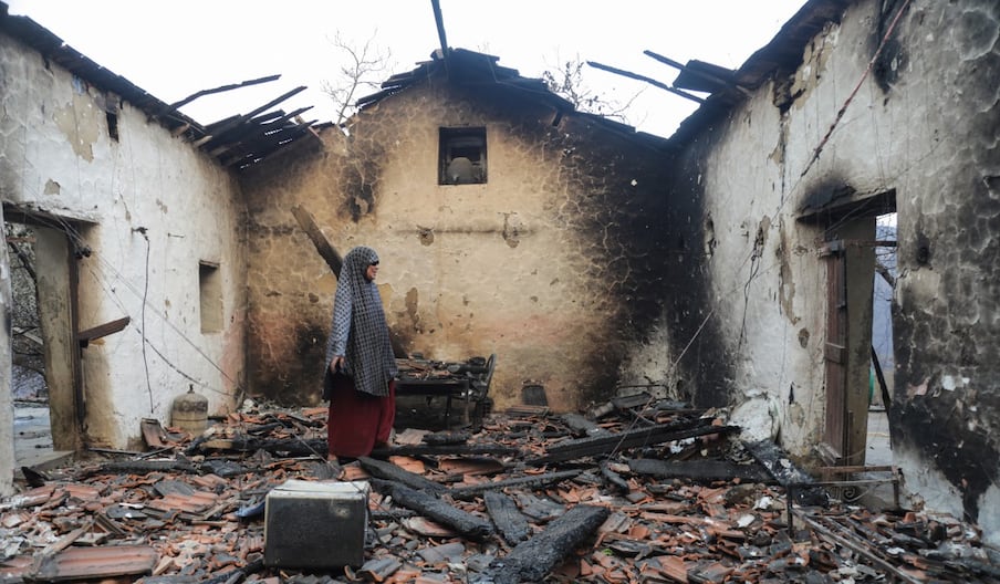 Une femme inspecte sa maison endommagée après qu'elle a été ravagée par un feu de forêt à Bordj T'har, une commune de la province de Jijel, dans le nord-est de l'Algérie, le 27 août 2026.