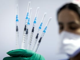 Une soignante porte dans sa main gantée des seringues contenant le sérum du vaccin Pfizer-BioNTech dans un centre de vaccination anti-Covid-19, dans la ville de Salé, le 5 octobre 2021.