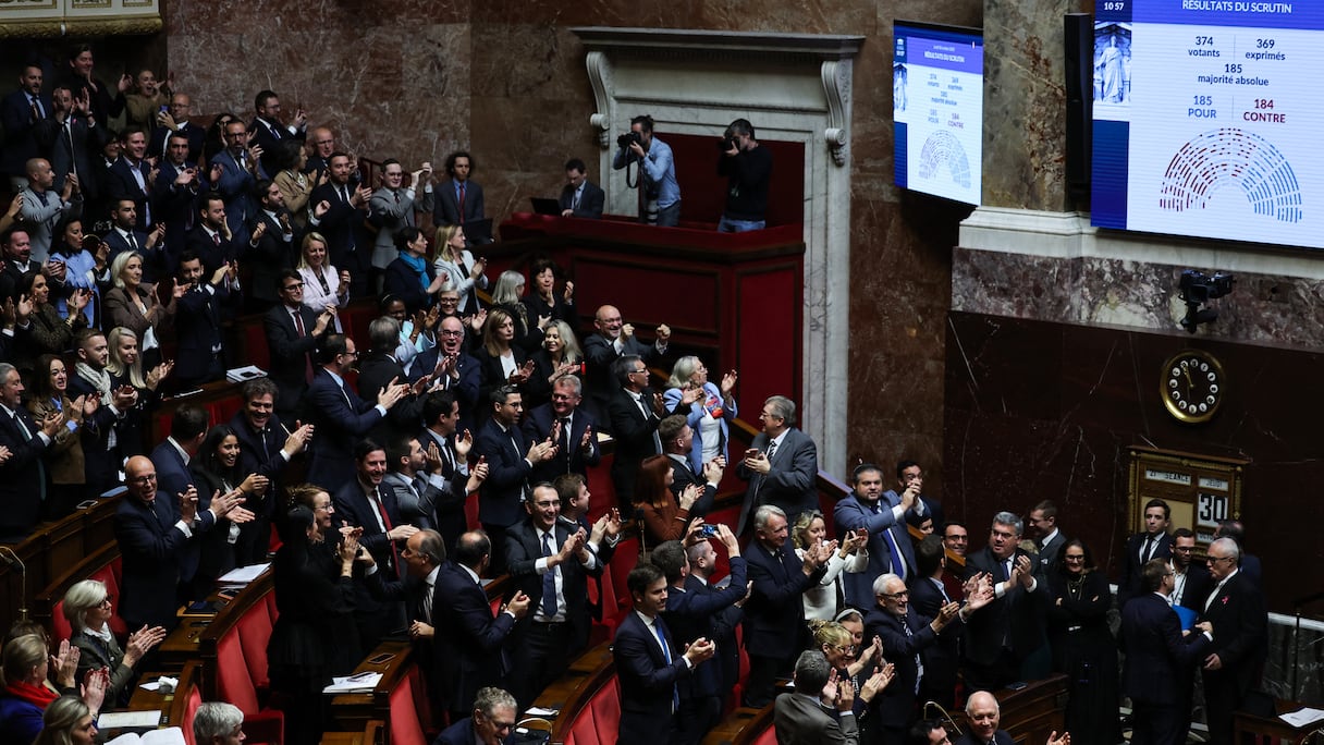 Des députés du RN applaudissent après un vote lors de l'examen des textes par la « niche parlementaire » du groupe d'extrême droite Rassemblement National, à l'Assemblée nationale, la chambre basse du parlement français, à Paris, le 30 octobre 2025. Les députés ont adopté, par 185 voix contre 184, une proposition de résolution du Rassemblement National visant à « dénoncer » l'accord franco-algérien de 1968, avec le soutien des groupes LR et Horizons.