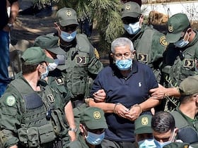 L'ancien Premier ministre algérien, Ahmed Ouyahia, menotté et sous haute surveillance dans un cimetière d'Alger, à l'enterrement de son frère, le 22 juin 2020.