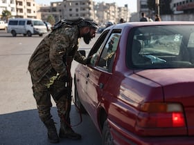 Un membre des forces de sécurité relevant du gouvernement intérimaire syrien vérifie l'identification d'un automobiliste à un point de contrôle à Homs, dans le centre-ouest de la Syrie, le 8 janvier 2025