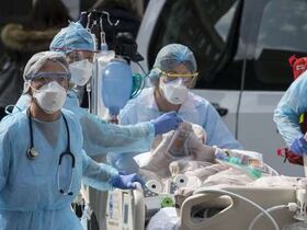 Des soignants emmènent un patient vers un hélicoptère médical, à l’hôpital Emile-Muller à Mulhouse (Haut-Rhin, France), le 22 mars 2020.
