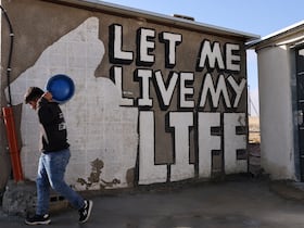 Un jeune Palestinien porte une bouteille de gaz dans le village de Khalet al-Daba'a, près de Yatta, dans le sud de la Cisjordanie occupée, après que les machines de l'armée israélienne ont démoli les structures et les zones d'habitation sur le site, le 13 février 2025